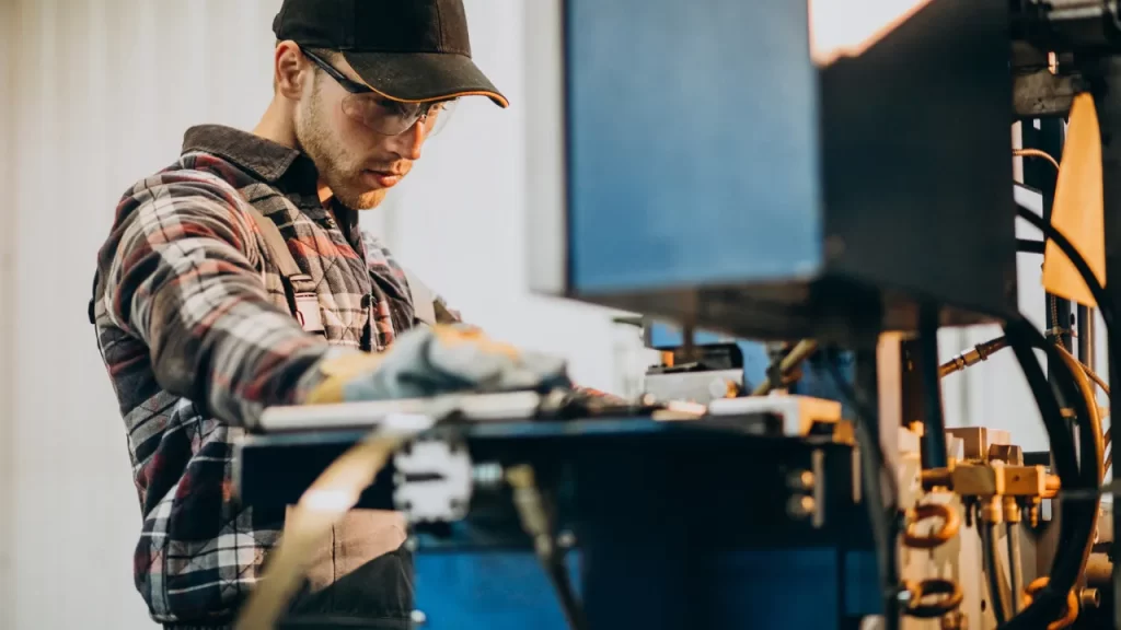 Profissional operando máquina CNC em ambiente industrial, concentrado no processo de usinagem de precisão.